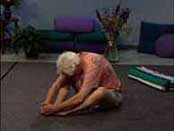 sitting on ground with soles of his feet together, man stretches forward